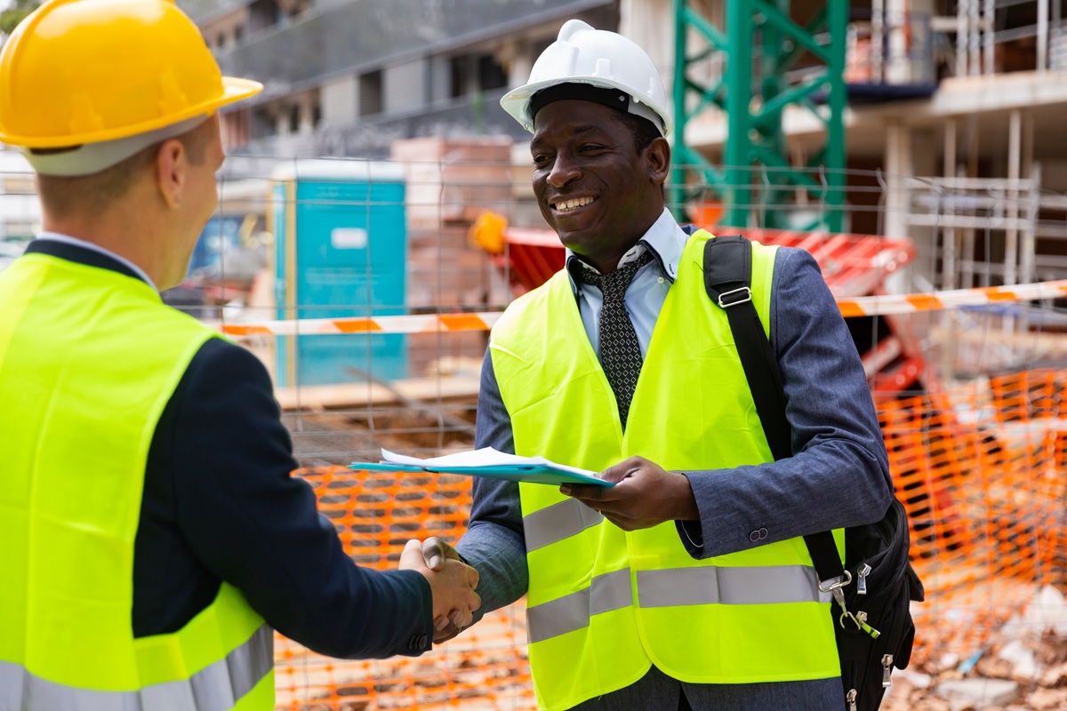 Two confident civil engineers exchange a friendly handshake